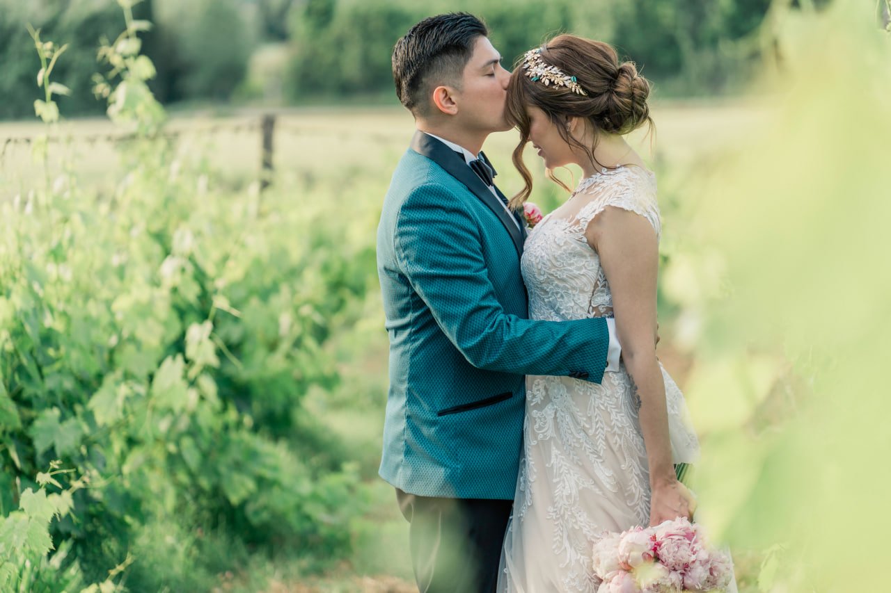 bride and groom kiss in the tuscan vineyard